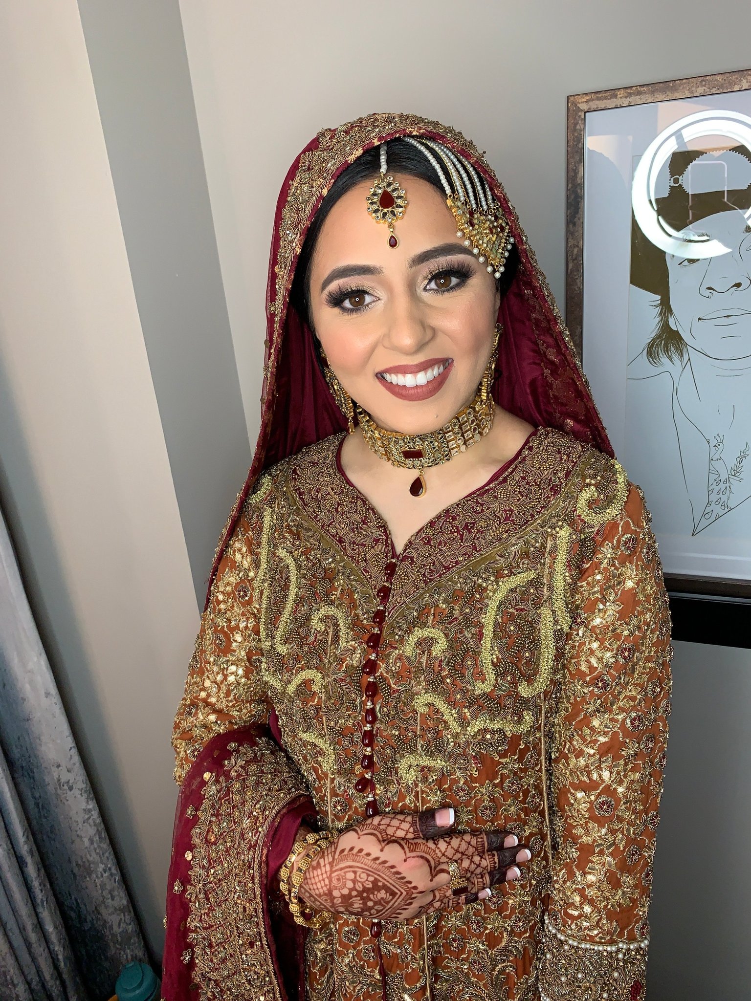 JTorry bride with makeup, hairstyling and a maroon bridal outfit