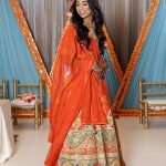 JTorry South Asian bridal haldi look: bride in orange outfit with marigold decor