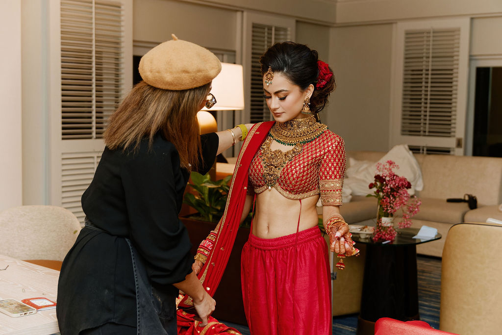 Jenny Torry adjusting a bride’s red dupatta as part of her complete bridal styling