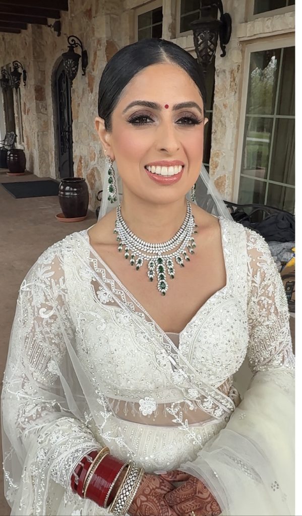 JTorry bride Rekha Thapa Basnet wearing an ivory embroidered bridal look with emerald and diamond jewelry