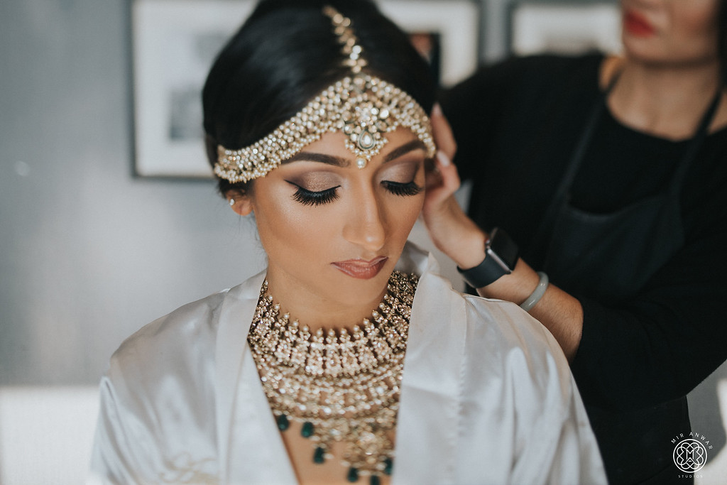 JTorry bridal getting-ready moment with makeup, hairstyling and jewelry finishing